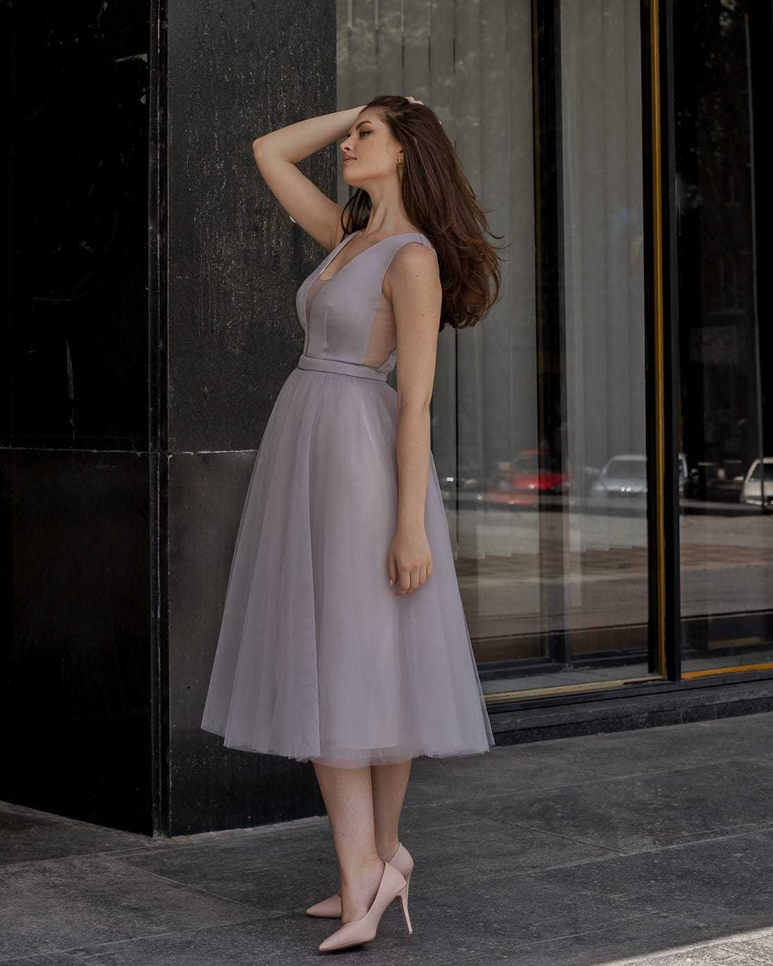 Rochie de ocazie gri midi cu decolteu și șiret la spate, din satin regal și tull, purtată de o femeie.