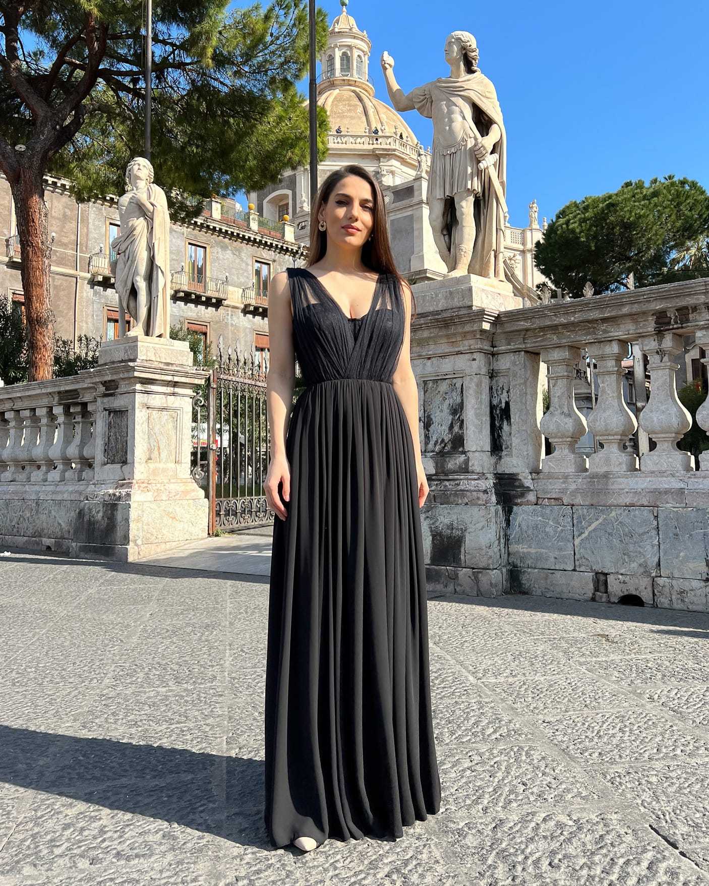 Rochie nunta neagră de ocazie cu corset din dantelă și slit senzual în decor urban.