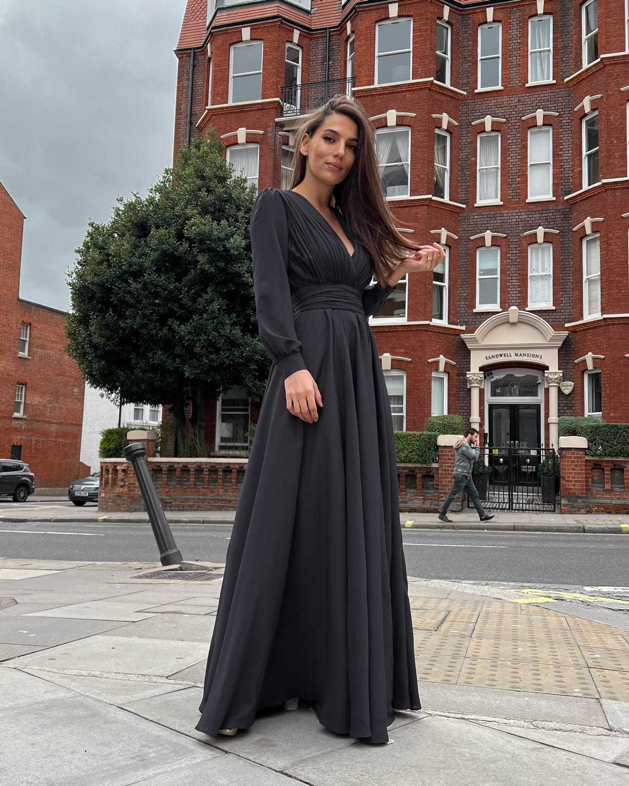 Rochie eleganta neagră de seară, lungă, cu pliuri și decolteu în V, mâneci lungi.